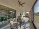 Bright screened porch with glass doors, seating area and ceiling fan at 16931 Scuba Crest St, Wimauma, FL 33598