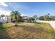 Spacious backyard with grassy area, screened enclosure, and palm tree at 1811 Stonebrook Ln, Safety Harbor, FL 34695