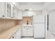 White kitchen with tile backsplash and sink at 2700 Bayshore Blvd # 6308, Dunedin, FL 34698