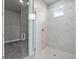 Walk-in shower with glass enclosure and marble-look tile at 44305 Timberland Ter, Punta Gorda, FL 33982