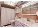 Clean bathroom with updated vanity, shower, and wood-paneled walls at 4575 Cove Cir # 304, St Petersburg, FL 33708