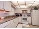Well-equipped kitchen featuring white cabinets at 4575 Cove Cir # 304, St Petersburg, FL 33708