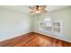Hardwood floor bedroom with ceiling fan and arched window at 6423 Driftwood Dr, Hudson, FL 34667