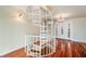 Elegant white spiral staircase in a hardwood floor entryway at 6423 Driftwood Dr, Hudson, FL 34667