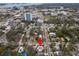 Aerial view of a pink house with solar panels, nestled in a tree-lined residential area at 700 S Prospect Ave, Clearwater, FL 33756