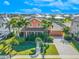 Two-story house with orange exterior, palm trees, and paver driveway at 710 Islebay Dr, Apollo Beach, FL 33572