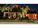 Two-story house with palm trees and landscape lighting at night at 710 Islebay Dr, Apollo Beach, FL 33572