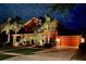 Two-story house with palm trees and landscape lighting at night at 710 Islebay Dr, Apollo Beach, FL 33572