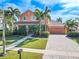 Two-story house with orange exterior, palm trees, and landscaped yard at 710 Islebay Dr, Apollo Beach, FL 33572