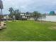 Expansive grassy backyard with canal views and a glimpse of a playground at 8540 Riverside, St Petersburg, FL 33702
