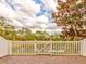 Brick patio with a white fence overlooking a pond at 11902 Greengate Dr, Hudson, FL 34669