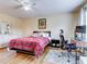Bright bedroom with hardwood floors, a workspace, and a cozy bed at 11902 Greengate Dr, Hudson, FL 34669