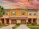 Tan two-story townhome with two-car garage and landscaping at 11902 Greengate Dr, Hudson, FL 34669