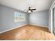 Bedroom with wood flooring, window with shutters and ceiling fan at 10454 Ventura Dr, Spring Hill, FL 34608