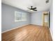 Bedroom with wood flooring, window with shutters and ceiling fan at 10454 Ventura Dr, Spring Hill, FL 34608