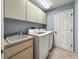Bright laundry room with washer, dryer, and cabinets at 10454 Ventura Dr, Spring Hill, FL 34608