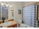 Bathroom with granite countertop, white sink, and blue striped shower curtain at 11518 Hammock Oaks Ct, Lithia, FL 33547