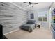 Cozy bedroom with wood-like accent wall, gray bedding, and window with shutters at 11518 Hammock Oaks Ct, Lithia, FL 33547