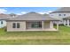 Back of house with covered patio and large backyard at 13028 Homestead Ln, Parrish, FL 34219