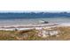 Peaceful beachfront view with small boat and calm waters at 131 Bluff View Dr # 103, Belleair Bluffs, FL 33770