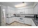 Bright kitchen with white cabinets and black countertops at 131 Bluff View Dr # 103, Belleair Bluffs, FL 33770
