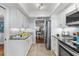 Modern white kitchen with stainless steel appliances and granite countertops at 131 Bluff View Dr # 103, Belleair Bluffs, FL 33770