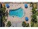 Community pool with lounge chairs and umbrellas from above at 131 Bluff View Dr # 103, Belleair Bluffs, FL 33770