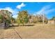 Fenced backyard with a large grassy area and mature trees at 1536 W Del Webb Blvd, Sun City Center, FL 33573