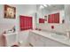 Bathroom with single sink, shower, and red accents at 1536 W Del Webb Blvd, Sun City Center, FL 33573