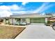 Green ranch home with stone accents, landscaping, and a two-car garage at 1536 W Del Webb Blvd, Sun City Center, FL 33573