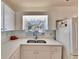 Bright kitchen features white cabinets, double sink, and ample counter space at 1536 W Del Webb Blvd, Sun City Center, FL 33573