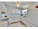 White kitchen with electric range, double sink, and ceiling fan at 1536 W Del Webb Blvd, Sun City Center, FL 33573