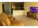 Spacious open floor plan featuring a modern sofa, a large TV and open kitchen at 1668 Hazy Sea Dr, Plant City, FL 33565