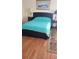 Bedroom with teal bedding, wood floors, and nightstands at 255 Capri N Cir # 17, Treasure Island, FL 33706