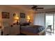 Spacious bedroom with a queen-size bed, a ceiling fan, and access to a balcony at 255 Capri N Cir # 17, Treasure Island, FL 33706