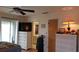 Well-lit bedroom with a queen bed, dresser, and view of the bathroom at 255 Capri N Cir # 17, Treasure Island, FL 33706