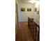 Upper hallway with wood floors, stairwell, and artwork at 255 Capri N Cir # 17, Treasure Island, FL 33706