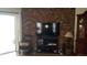 Living room with brick wall, flat-screen TV, and built-in shelving at 255 Capri N Cir # 17, Treasure Island, FL 33706