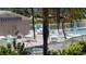 Community pool and spa with patio furniture and lush landscaping at 255 Capri N Cir # 17, Treasure Island, FL 33706