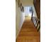 Wooden staircase with dark brown railing and upper landing at 255 Capri N Cir # 17, Treasure Island, FL 33706