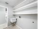 Laundry room with shelving, utility sink, and access to other rooms at 2712 Mock Orange Ct, Valrico, FL 33594