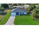 Aerial view of a light blue house with a paved driveway and grassy yard at 3038 Sargeant St, Port Charlotte, FL 33948