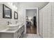 Modern bathroom with double sinks, gray cabinets, and a shower at 3607 Trafalgar Way # 103, Palm Harbor, FL 34685