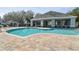 Resort-style community pool with lounge chairs and clubhouse in background at 3607 Trafalgar Way # 103, Palm Harbor, FL 34685