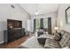 Bright living room with hardwood floors, sectional sofa, and access to a patio at 3607 Trafalgar Way # 103, Palm Harbor, FL 34685