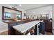 Home bar with white countertop, beverage fridge, and mirror at 3756 E Lake Dr, Land O Lakes, FL 34639