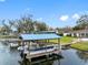 Covered dock with pontoon boat on a calm lake at 3756 E Lake Dr, Land O Lakes, FL 34639