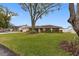 Ranch style home with lush landscaping and large shade trees in front at 3756 E Lake Dr, Land O Lakes, FL 34639