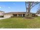 Single story home with attached garage, manicured lawn, and large shade tree at 3756 E Lake Dr, Land O Lakes, FL 34639