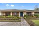 Ranch style home with teal front door and well-maintained landscaping at 3756 E Lake Dr, Land O Lakes, FL 34639